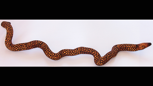 Wood carving of a desert snake by Francine Kulitja