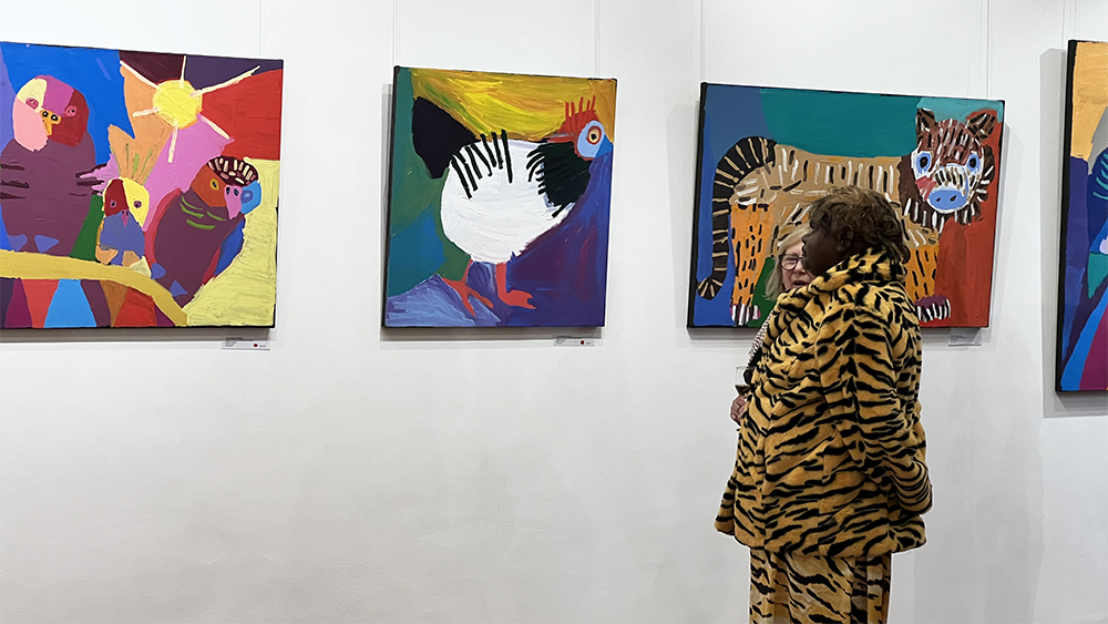 Warlukurlangu Artist Karen Napaljarri Barnes viewing her artworks at her solo show at KOG