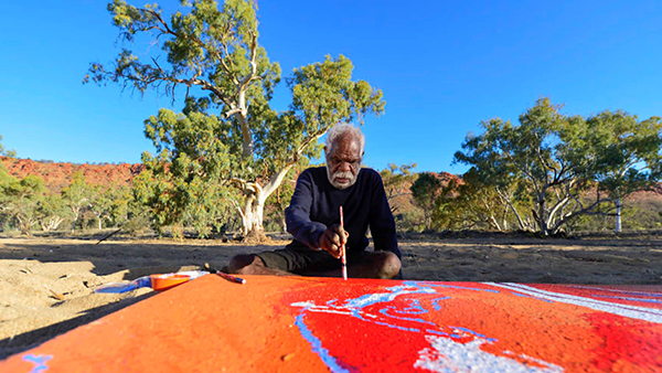 Tommy Watson painting next to the Todd River