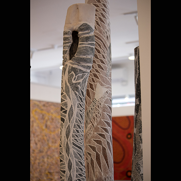 Example of Larrakitj memorial Poles on display at Kate Owen Gallery alongside Aboriginal paintings