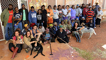 a large group photo of the Warlukurlangu Artists outside the art centre