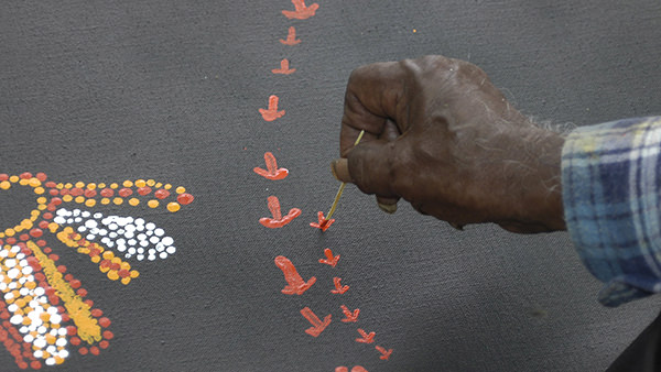 Jimmy Baker painting the tracks of the Ancestral Emu